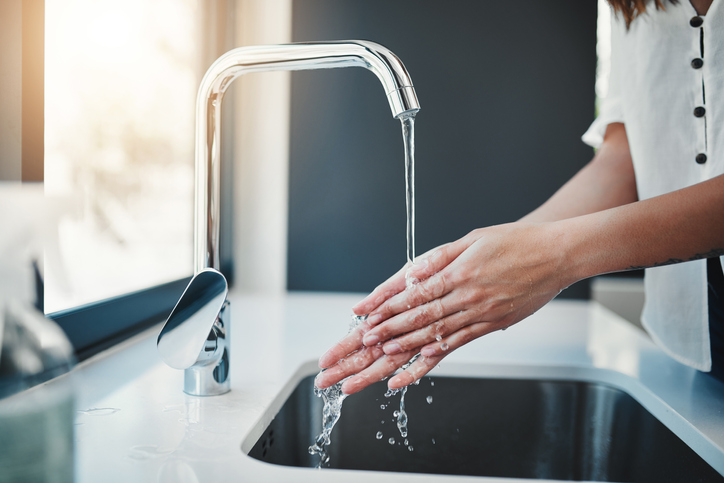washing hands under modern faucet